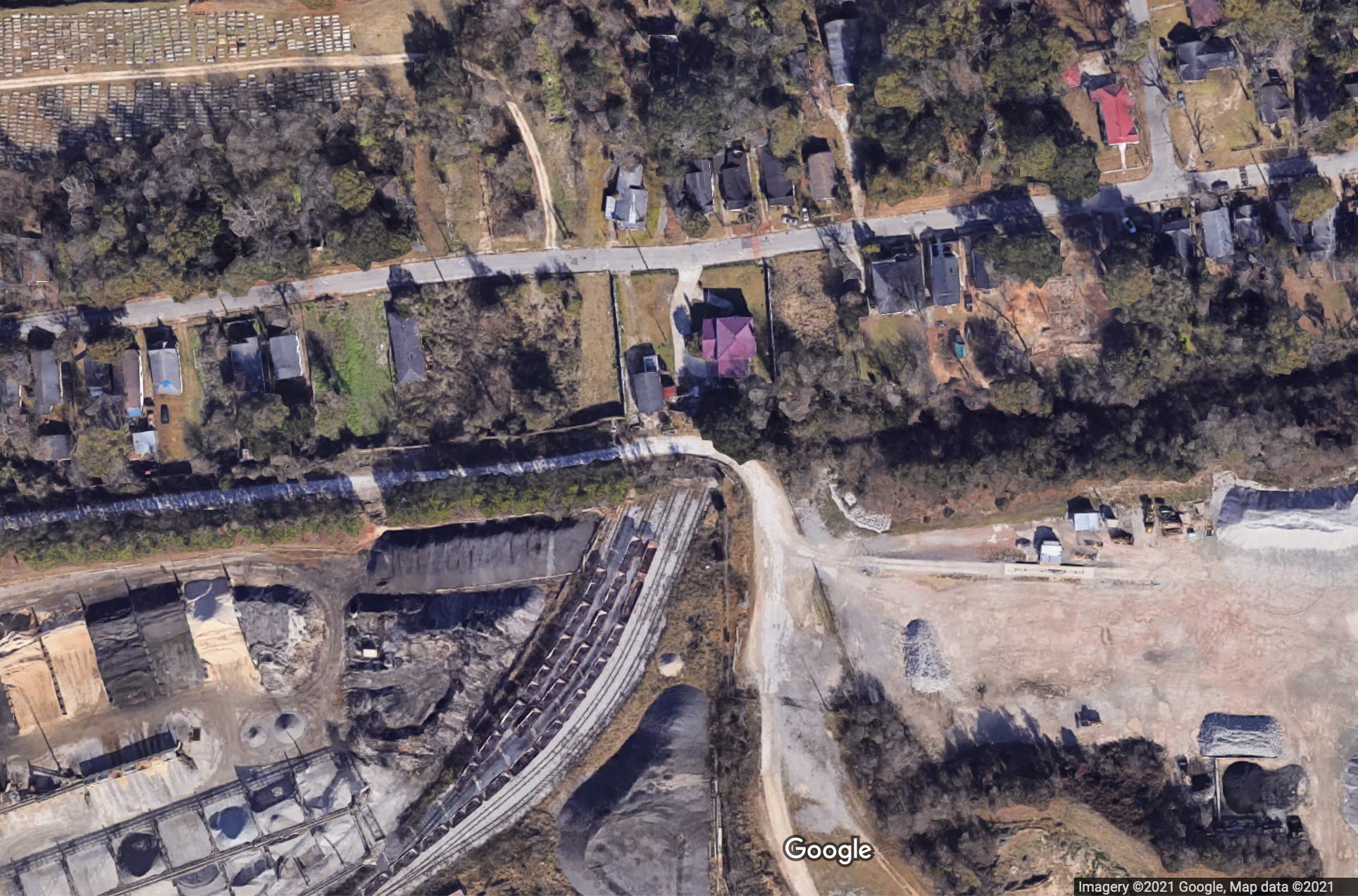 An satellite image of homes with industrial activities just along their backyard fences.